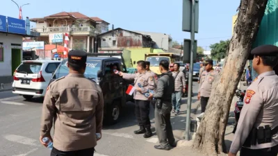Kapolres Pelabuhan Tanjung Priok Bagikan Bendera Merah Putih, Ajak Masyarakat Kobarkan Semangat Nasionalisme
